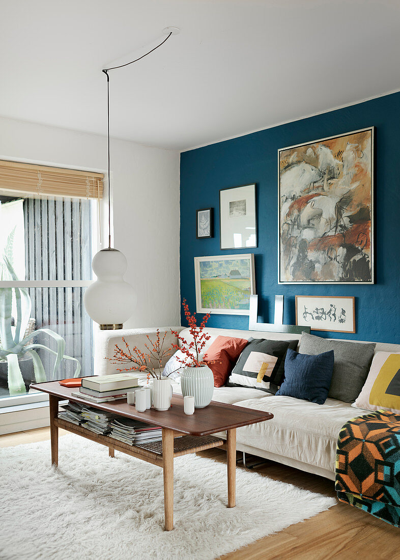 Gallery of pictures on blue wall in classic living room