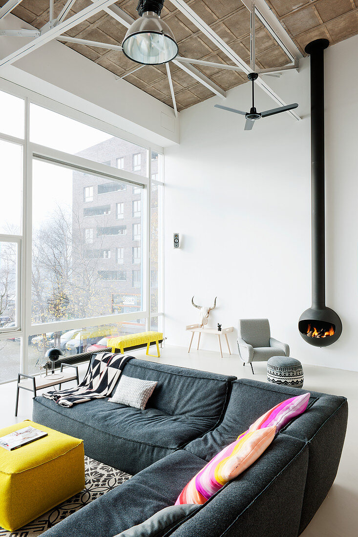 Modernes Wohnzimmer mit grauem Ecksofa im Loft mit Hängekamin