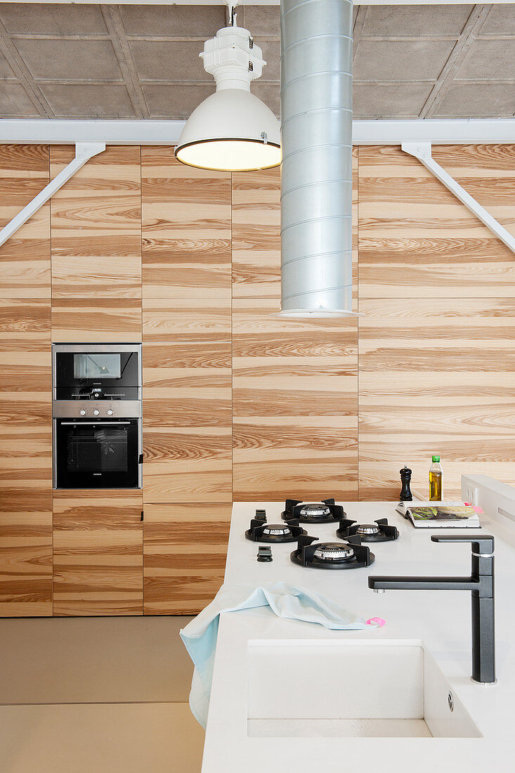 Einbauschrank mit Holzfronten in moderner Küche in einem Loft