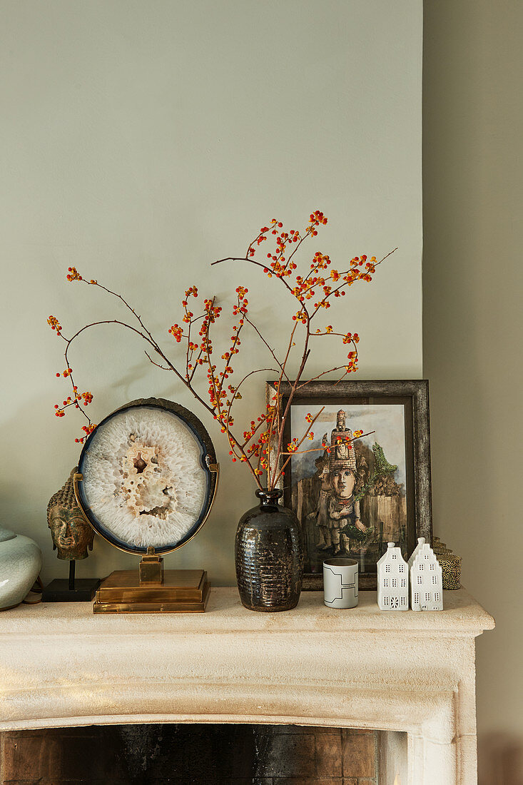 Sprigs of berries, geode and vintage ornaments on mantelpiece
