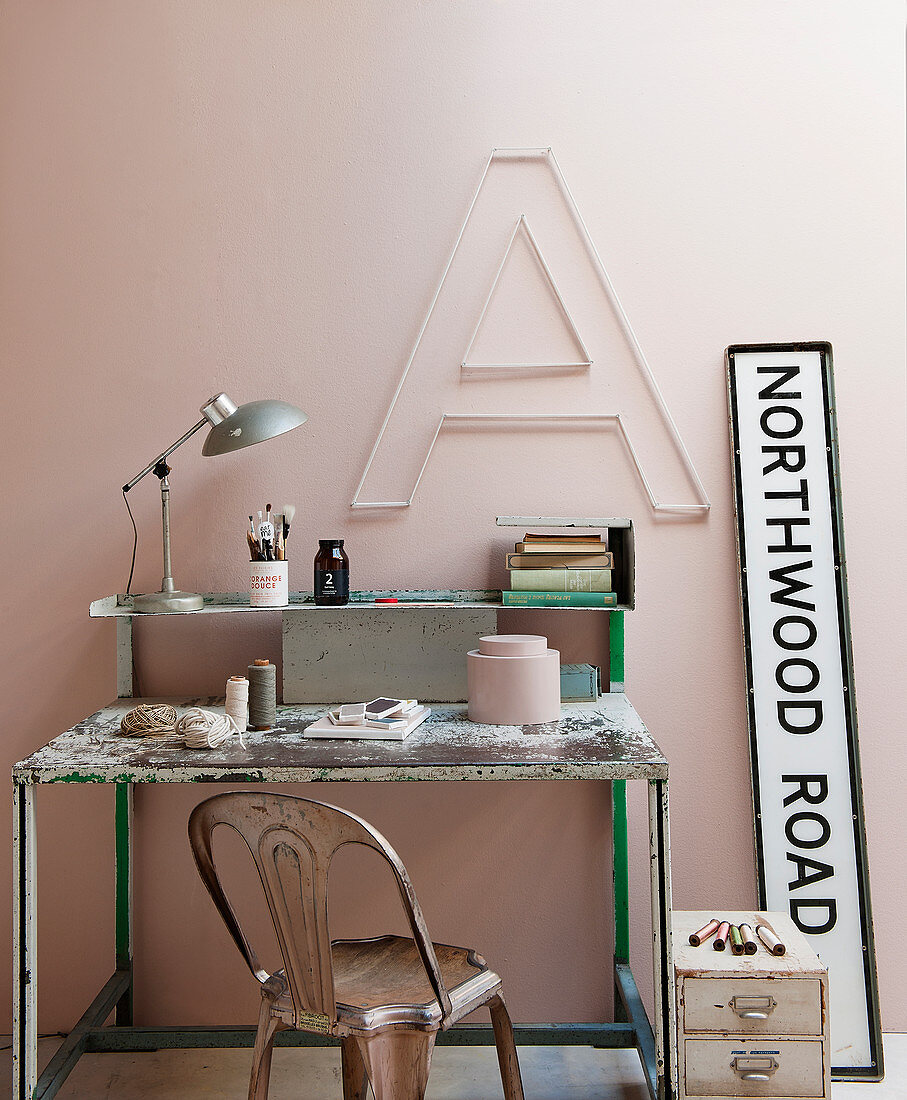 Vintage Schreibtisch und Stuhl vor rosafarbener Wand mit Dekobuchstabe