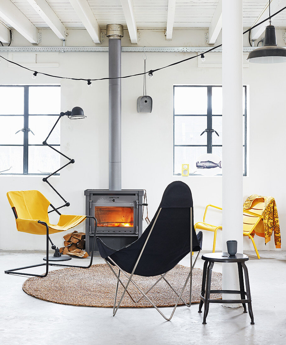 Outdoor chairs in black and yellow in front of wood burner in living room