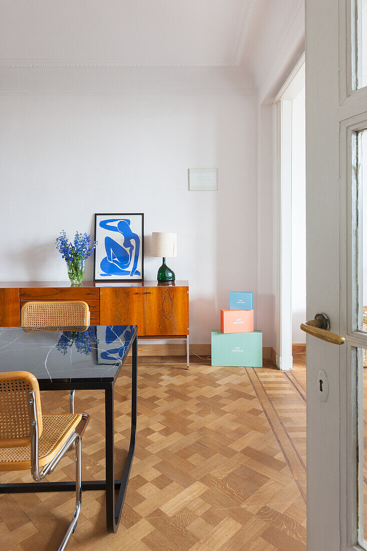 Modernes Esszimmer mit Holzfurnier-Sideboard und geometrischem Parkettboden