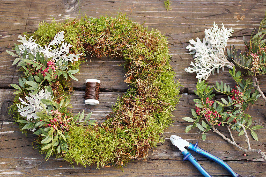 Tie a wreath of wild pistachio and silver leaves on moss