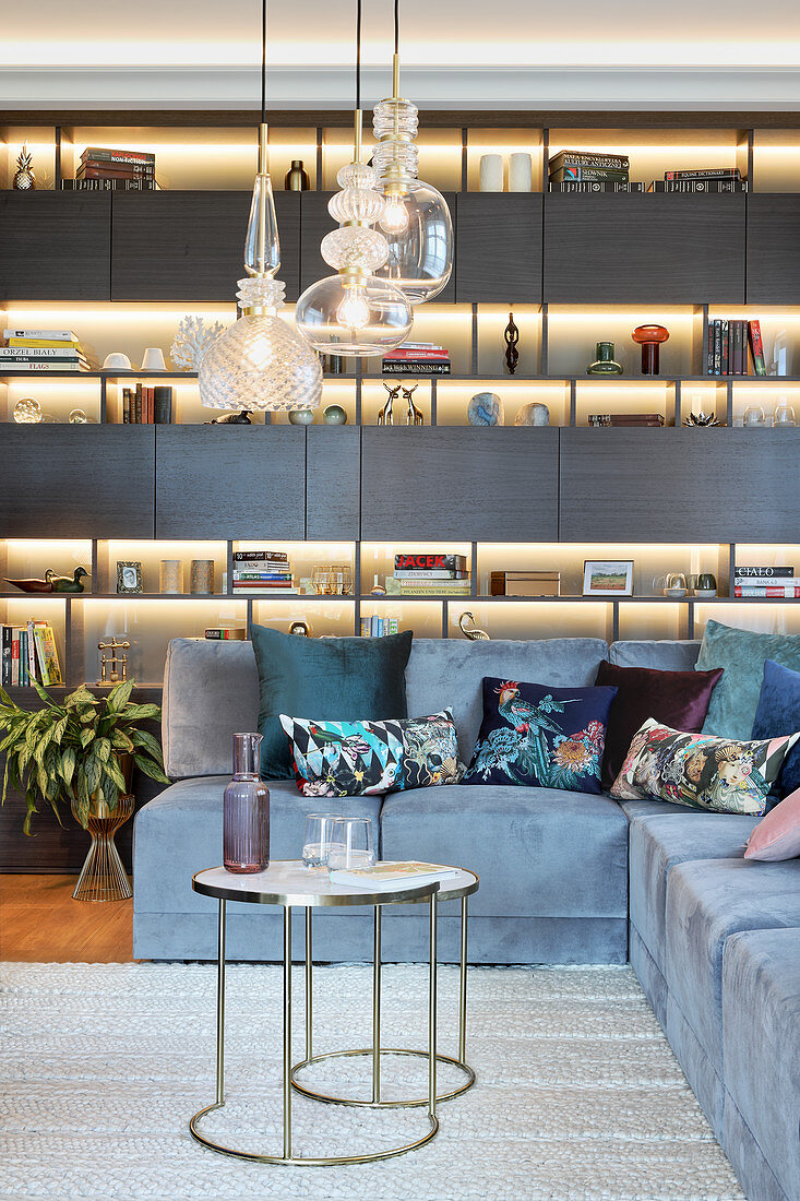 Illuminated shelving in elegant living room with corner sofa