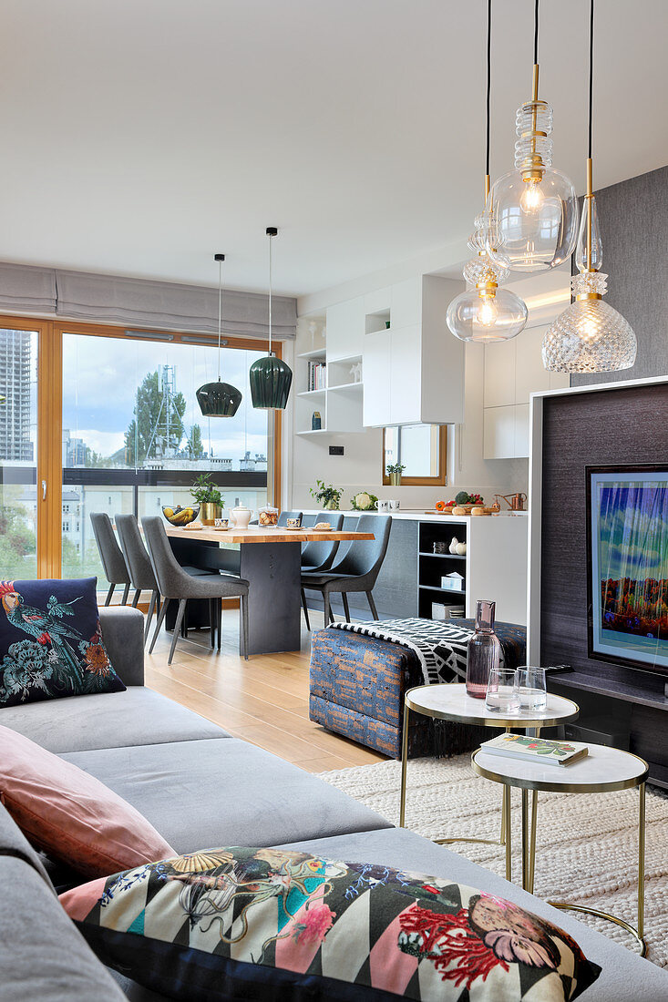 Open-plan kitchen in modern, multifunctional interior decorated in grey