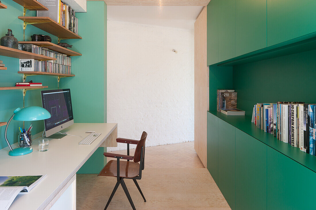 Work area with green built-in cupboards and wall shelves