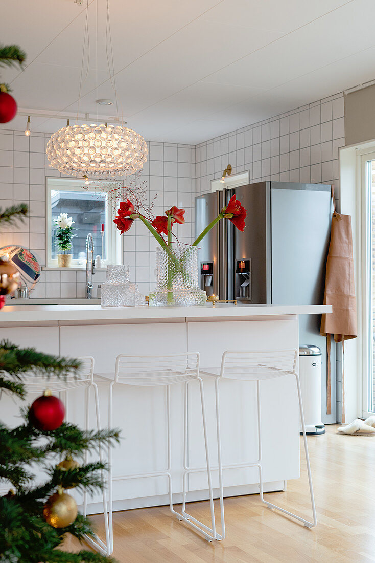 Slender barstools at counter in open-plan kitchen decorated for Christmas