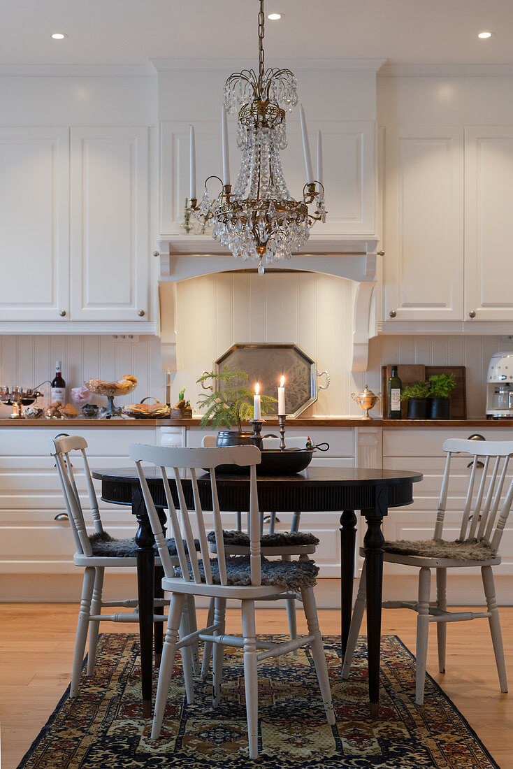 Sprossenstühle um runden Tisch in klassischer Küche in Weiß