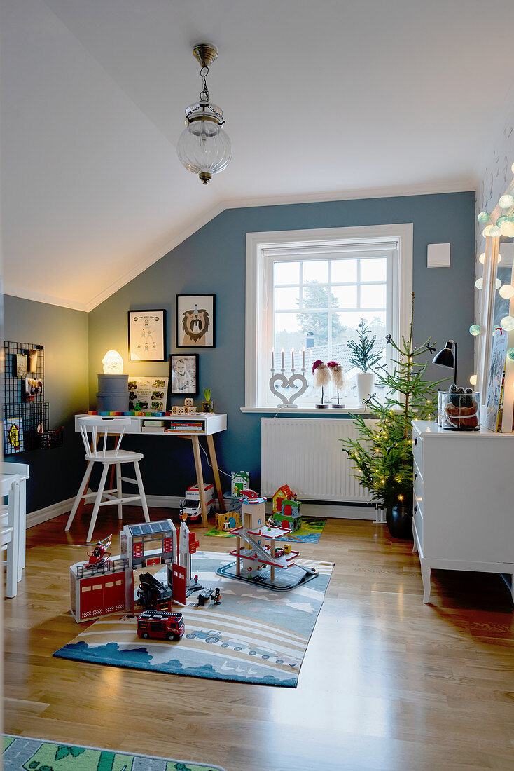 Kinderzimmer unter der Schräge mit blauer Wand und Weihnachtsbaum
