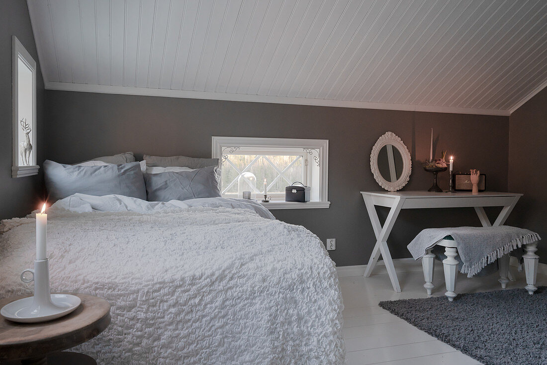 Bedroom decorated in white and grey with sloping ceiling