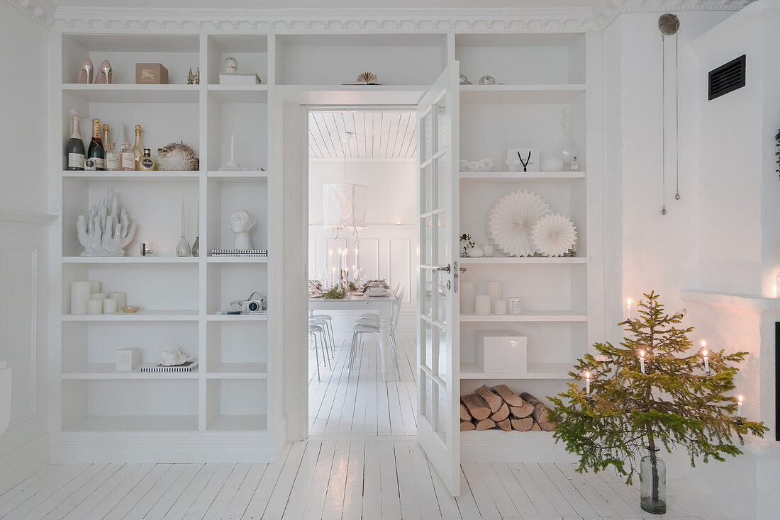 Fitted shelving surrounding door in classic, white living room