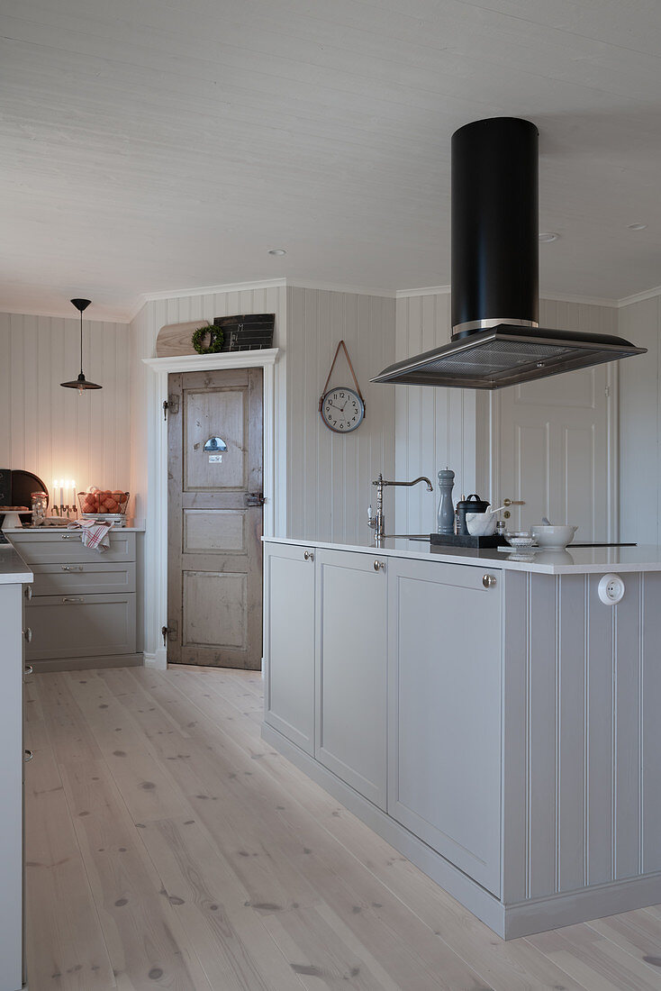 Island counter in Scandinavian country-house kitchen decorated in white and grey