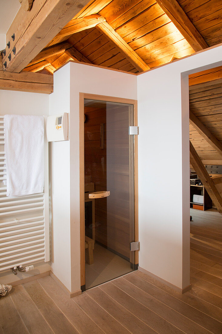 Small sauna in modern bathroom with sloping ceiling in country house