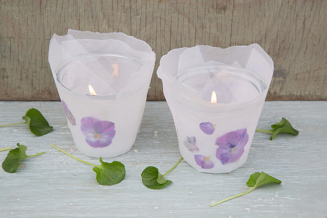 Candle lanterns decorated with parchment paper and pressed violas