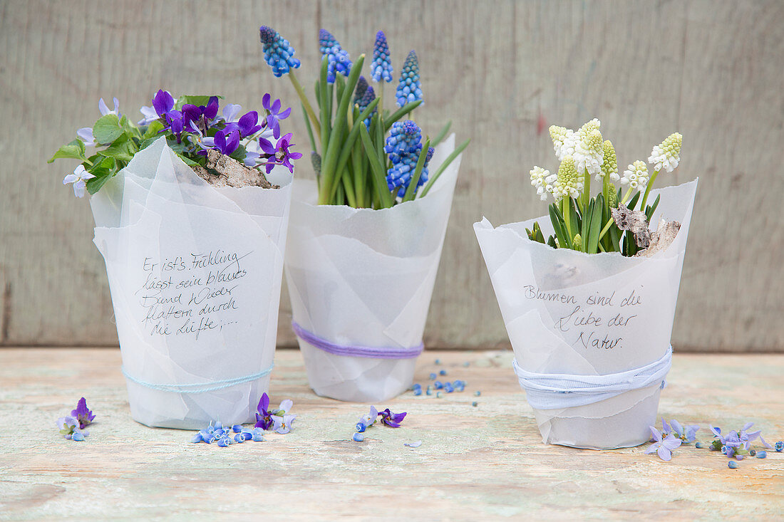 Spring flowers wrapped in parchment paper with handwritten mottoes