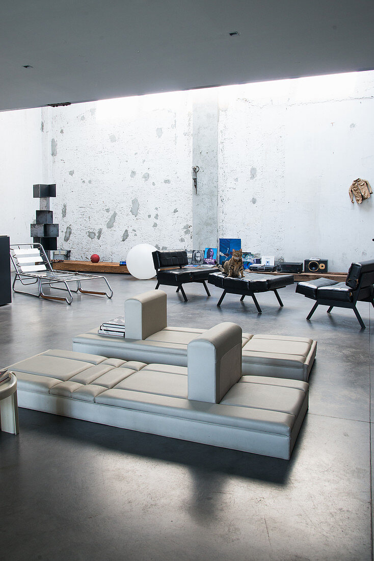 Designer furniture in lounge of industrial loft apartment
