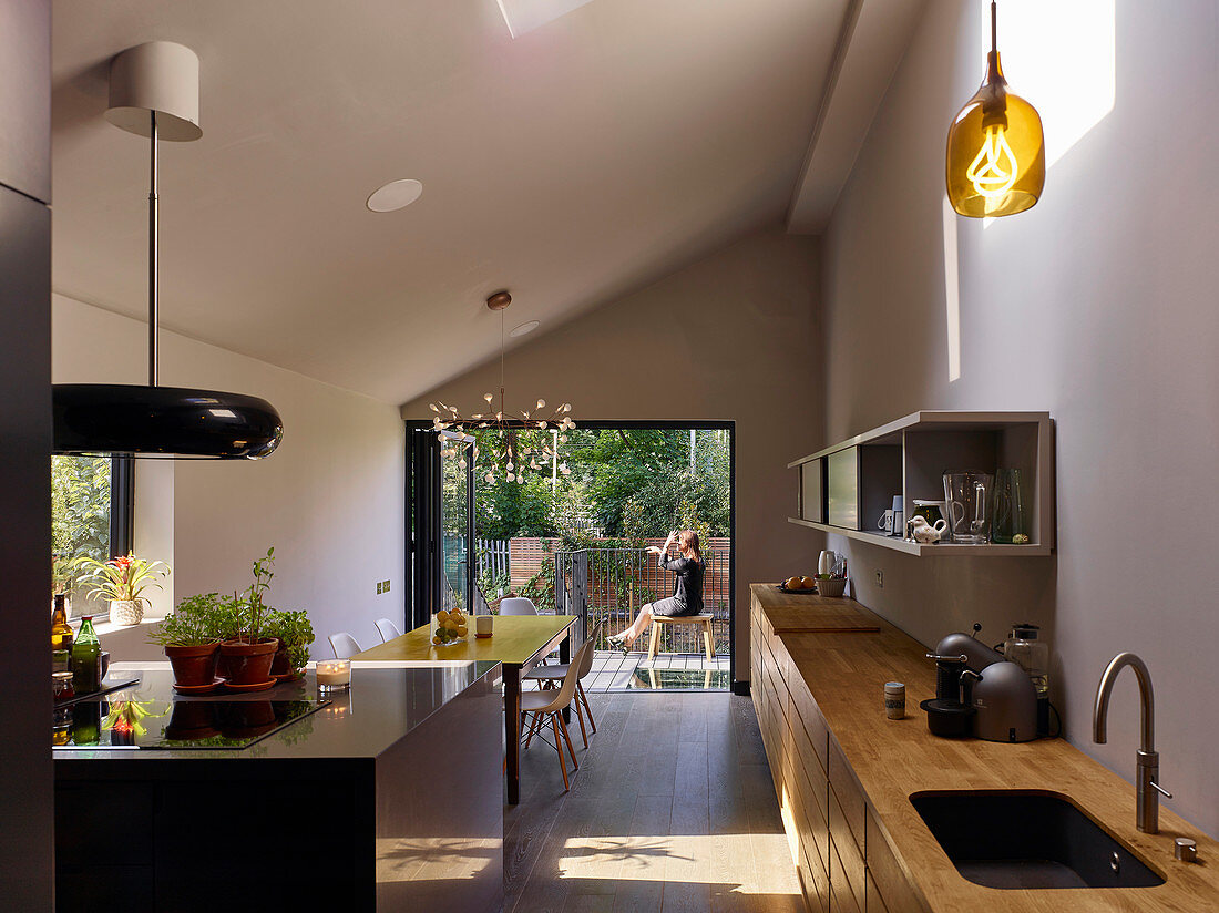 Moderner Wohnraum mit offener Küche, Esstisch und Gartenzugang