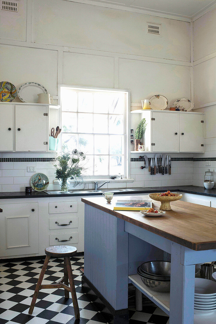 Rural kitchen with centre island and black and white tiled floor