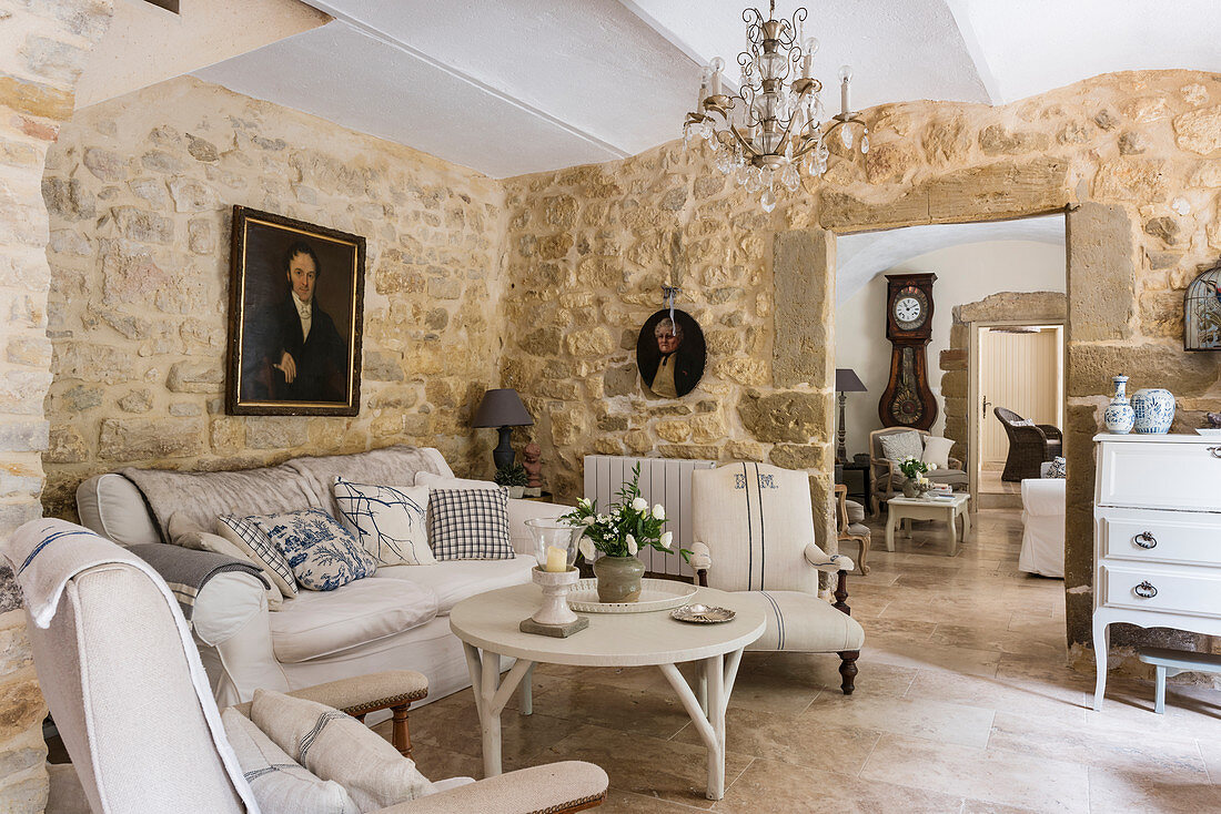 French travertine floors, crystal chandelier, stone walls and seating area in living room