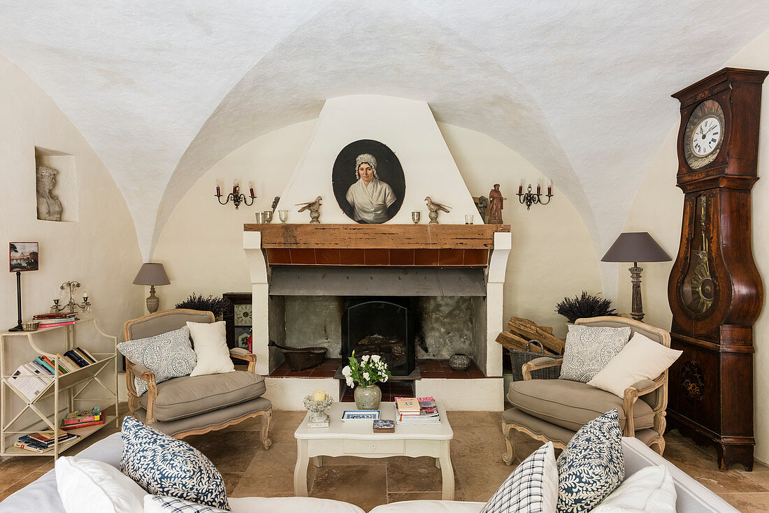 Armchairs flanking fireplace in living room with white-painted vaulted ceiling