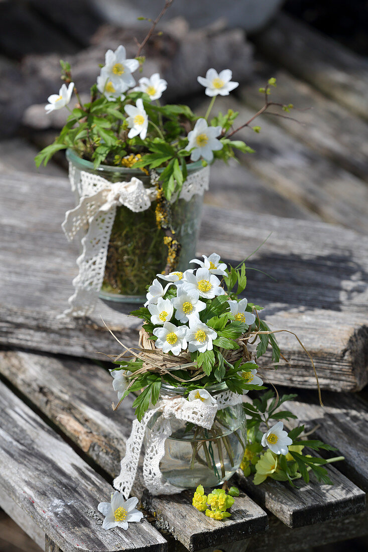 Small bouquets of wood anemones with a grass cuff and lace ribbon