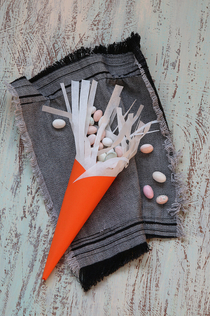 Handmade cone with fringe holding small Easter eggs