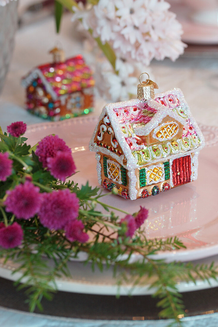 Christmas-tree decoration in shape of gingerbread house on plate