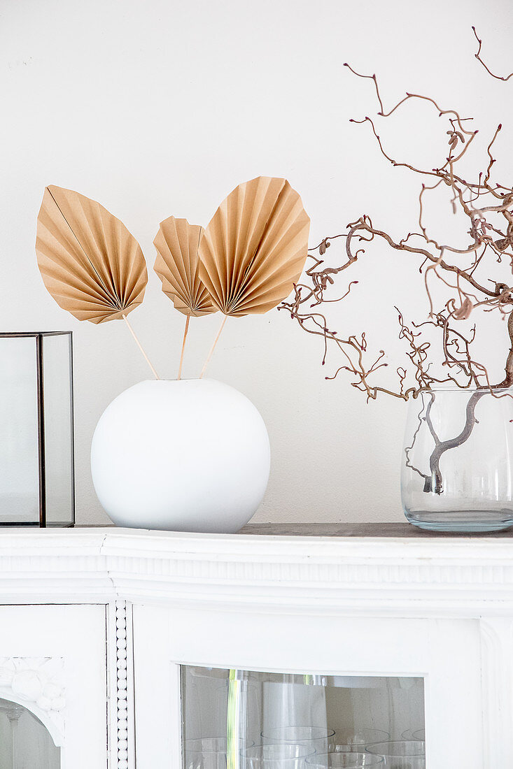DIY palm leaves made from brown paper in white spherical vase