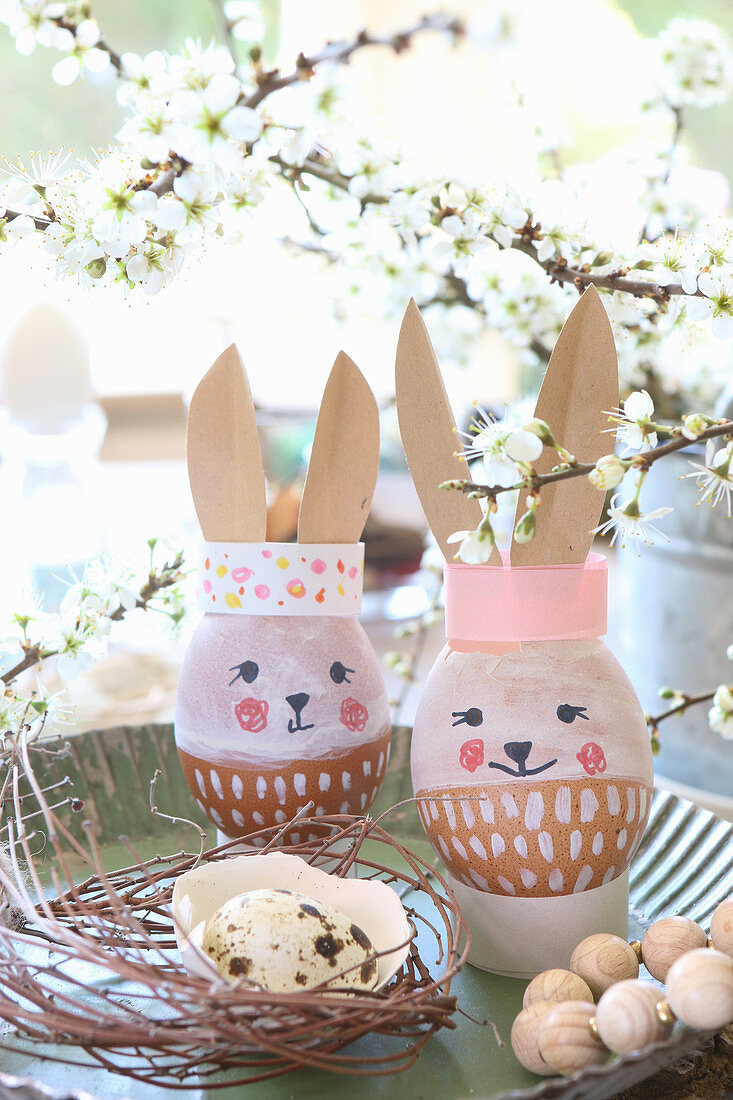Easter eggs with painted faces and paper bunny ears