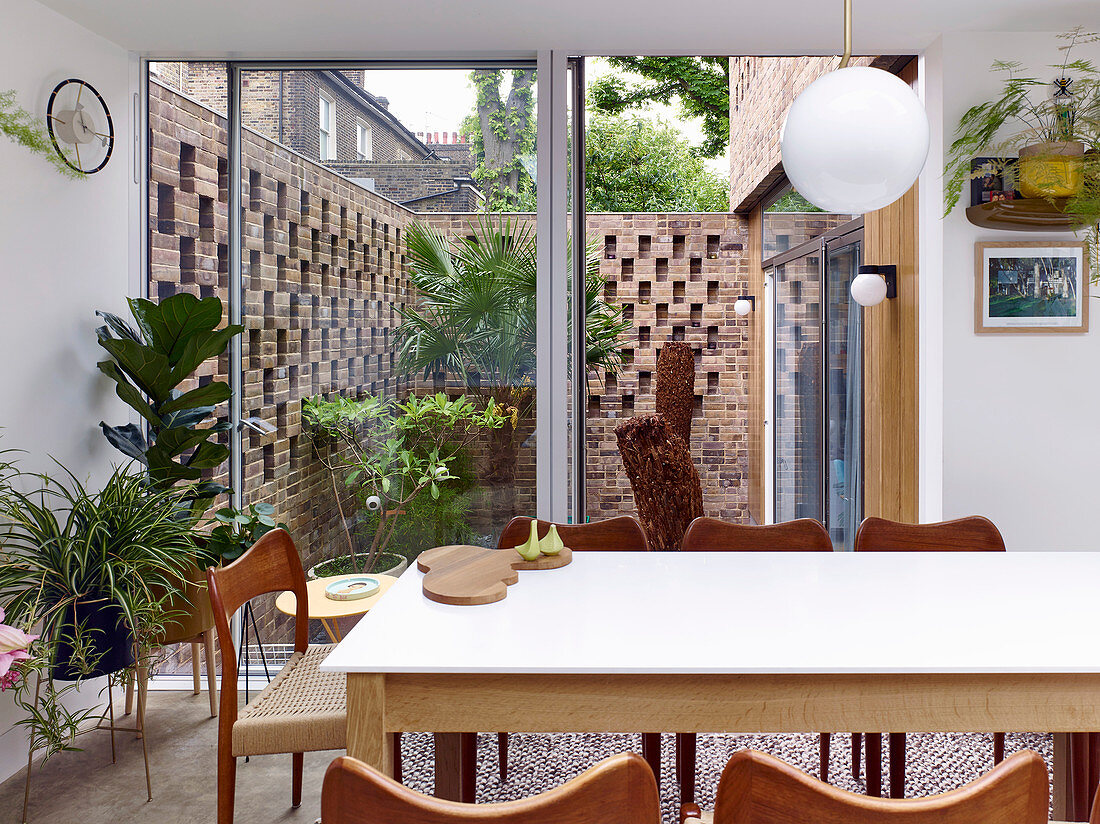 View from dining room into small courtyard garden with decorative brick walls