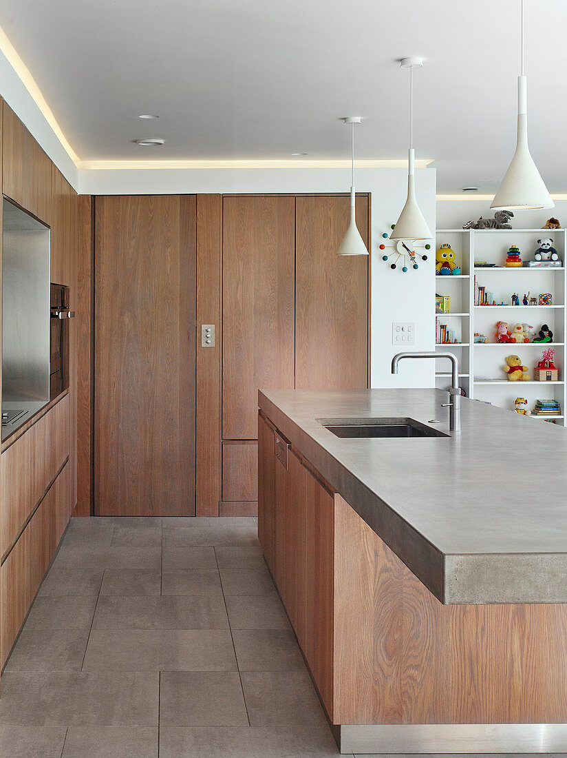 Designerküche mit Holzfronten und Betonarbeitsplatte auf Kücheninsel