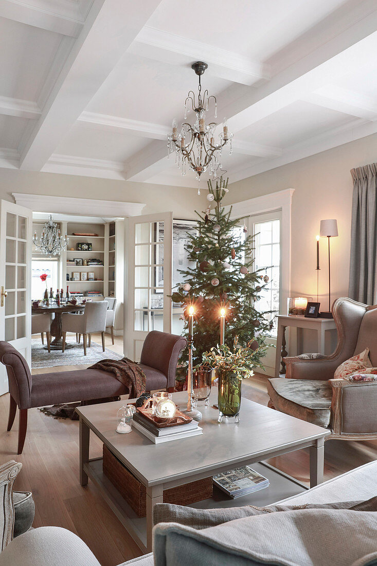 Blick über Couchtisch auf Weihnachtsbaum im Wohnzimmer mit Kassettendecke