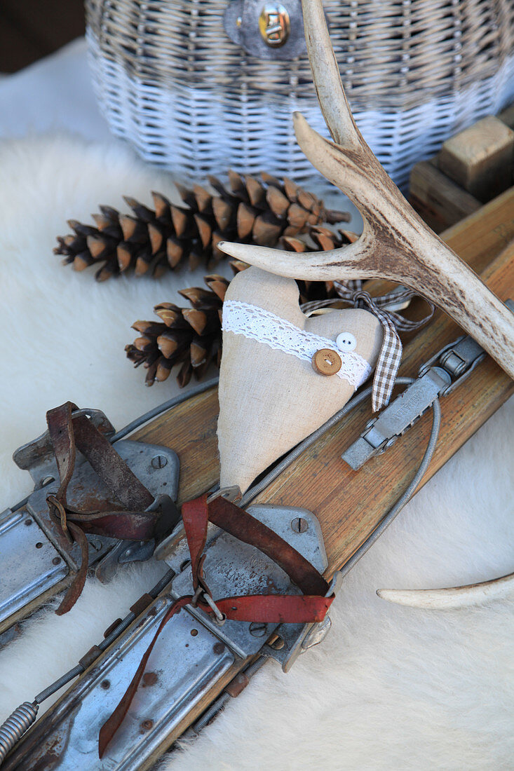 Arrangement of old wooden skis, pine cones, love heart and antlers