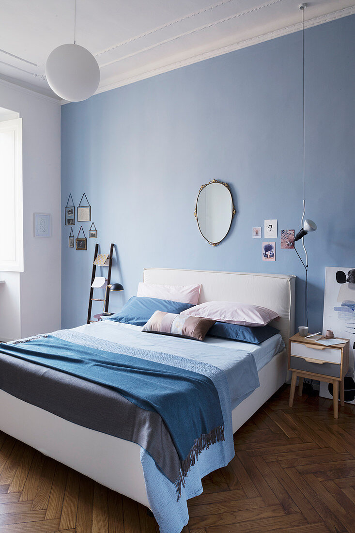 Bedroom in shades of blue with herringbone parquet floor in period building