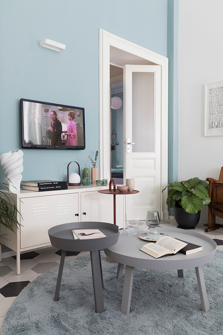 Runde Couchtische im Wohnzimmer mit blauer Wand