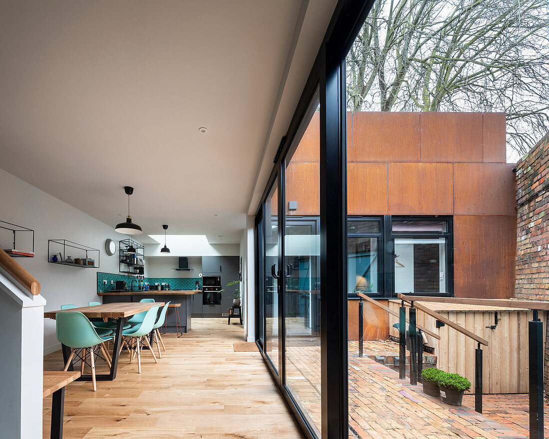 Modernes Architektenhaus mit rostiger Fassade und offenem Wohnraum