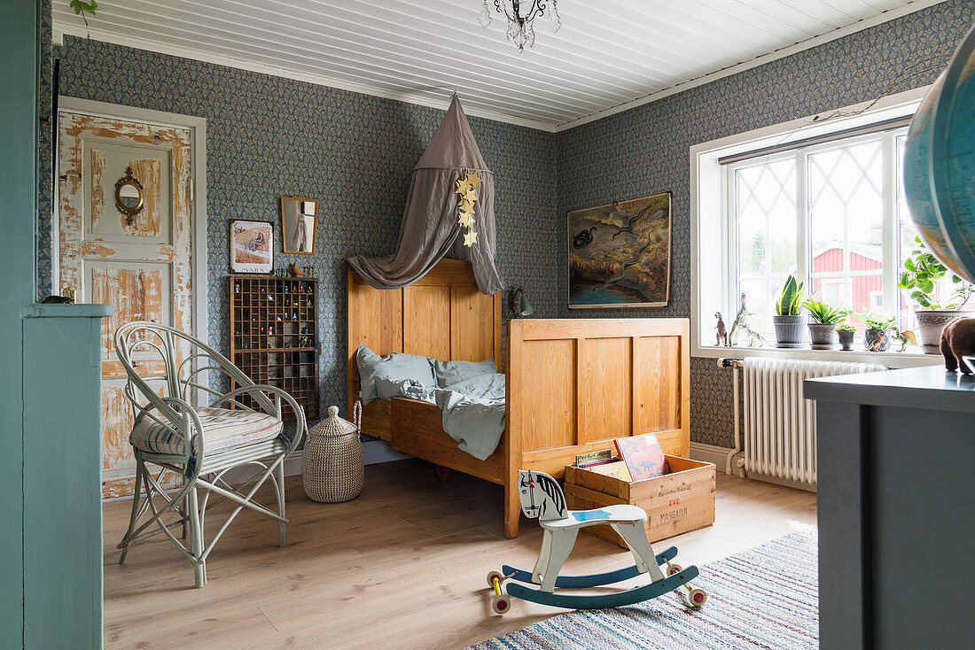 Antikes Holzbett mit Betthimmel, Stuhl und Schaukelpferd im Kinderzimmer