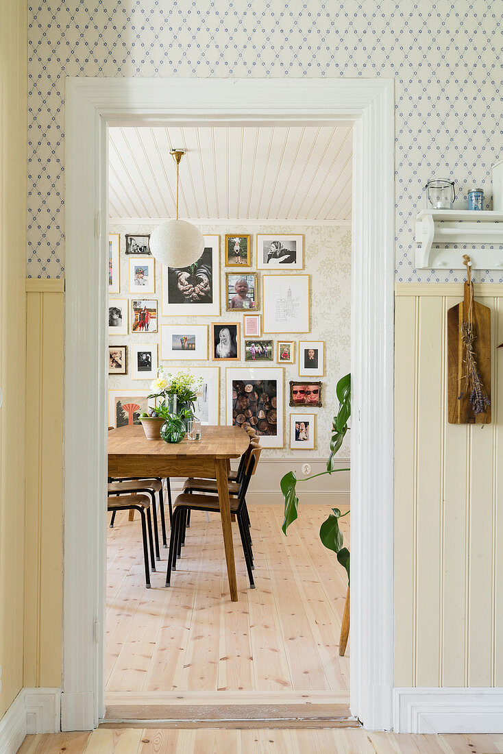 View into dining room with gallery of pictures on wall