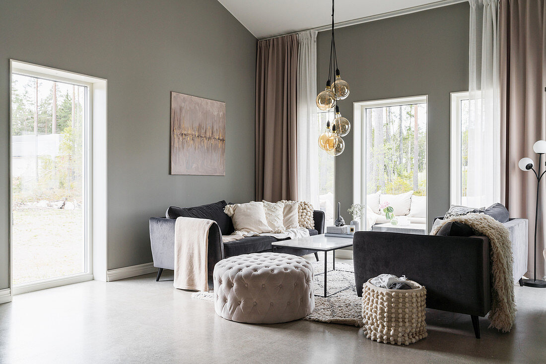 Pouffe and sofa in living room with grey walls
