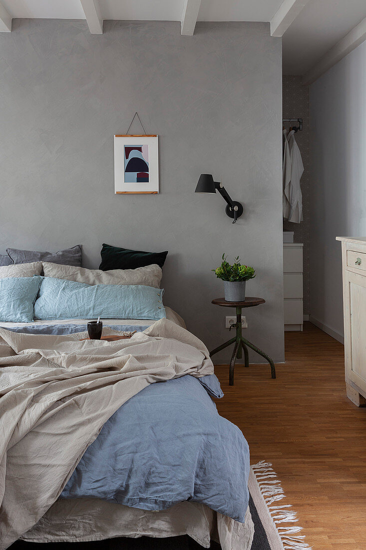 Doppelbett im Schlafzimmer mit grauer Wand