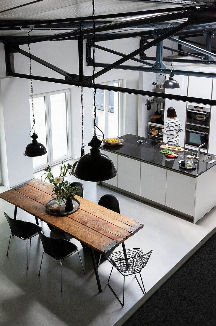 Rustikaler Esstisch mit Klassikerstühlen in offener Küche mit Kücheninsel