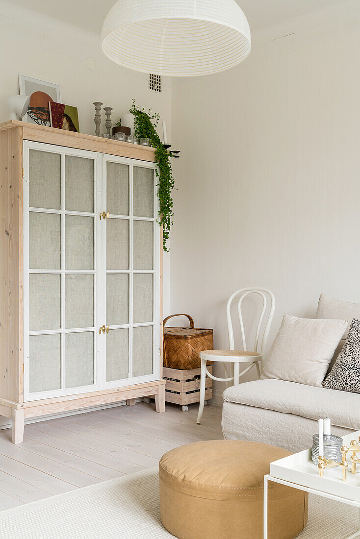 Schrank mit stoffbezogenen Türen aus alten Fenstern in Wohnzimmerecke