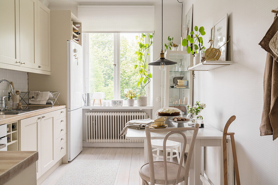 Tisch mit zwei Stühlen in heller Küche mit weiß geöltem Holzboden