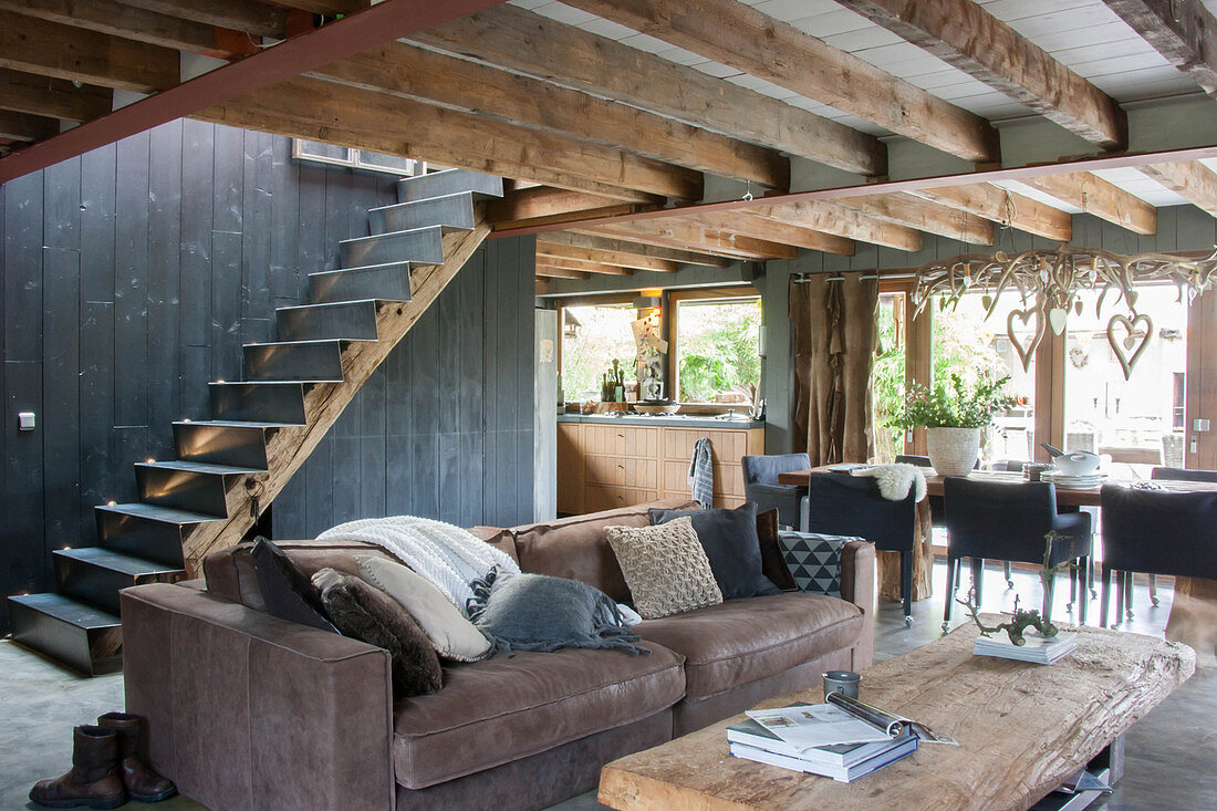 Brown sofa in rustic interior with wood-beamed ceiling