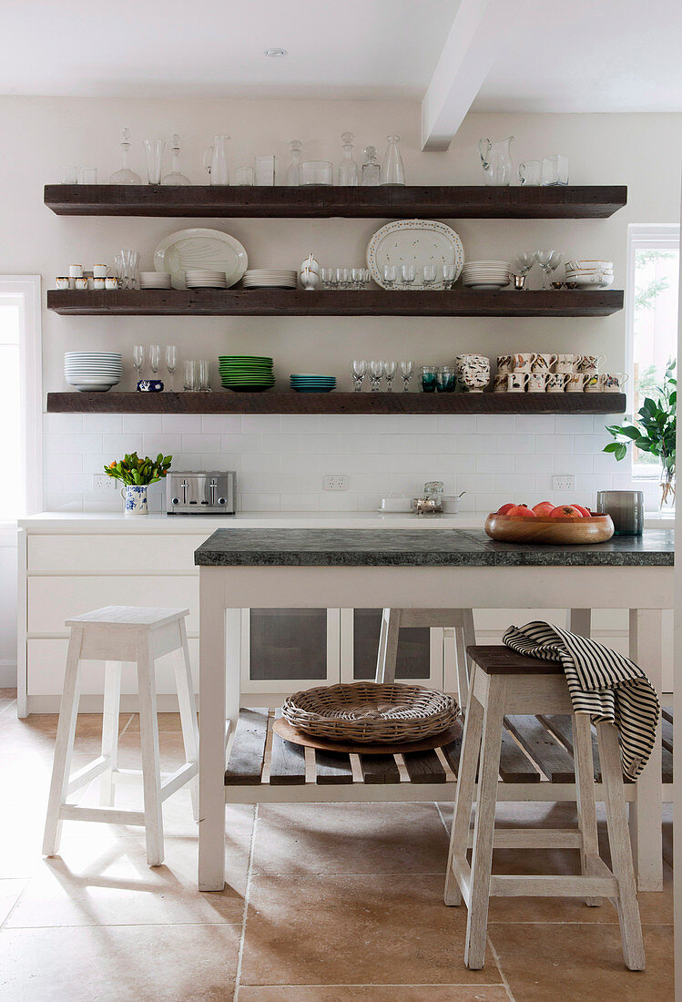 Crockery on shelves in modern country kitchen in white