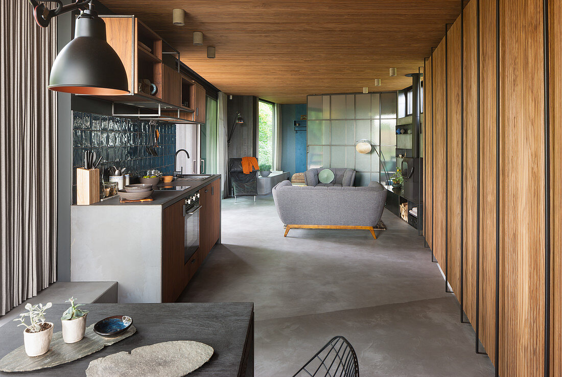 View past dining table to kitchen counter and seating area in background in open-plan interior