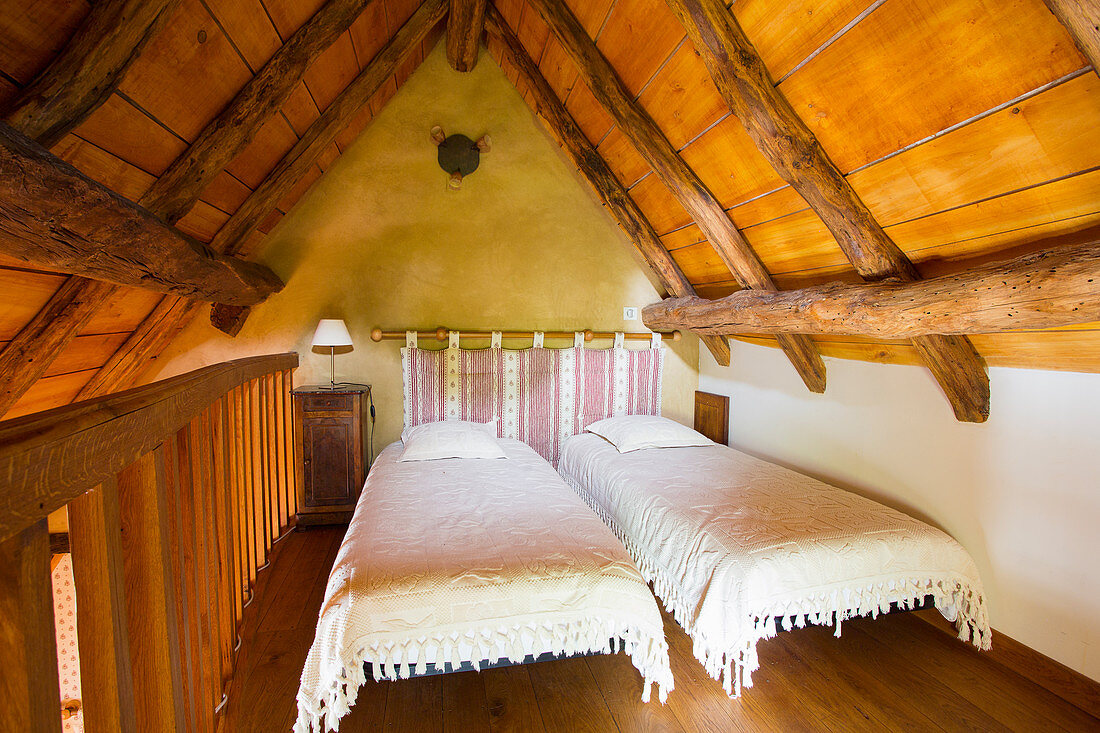 Twin beds in rustic attic bedroom
