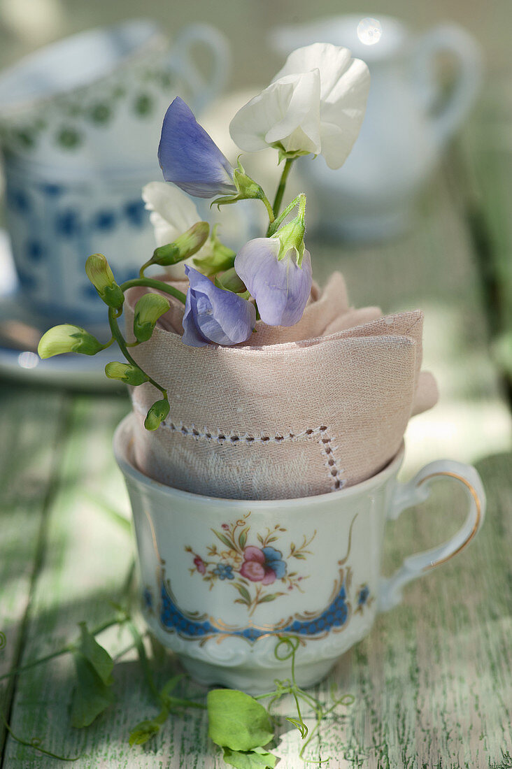 Kleine Tasse mit Duftwicken in Serviette