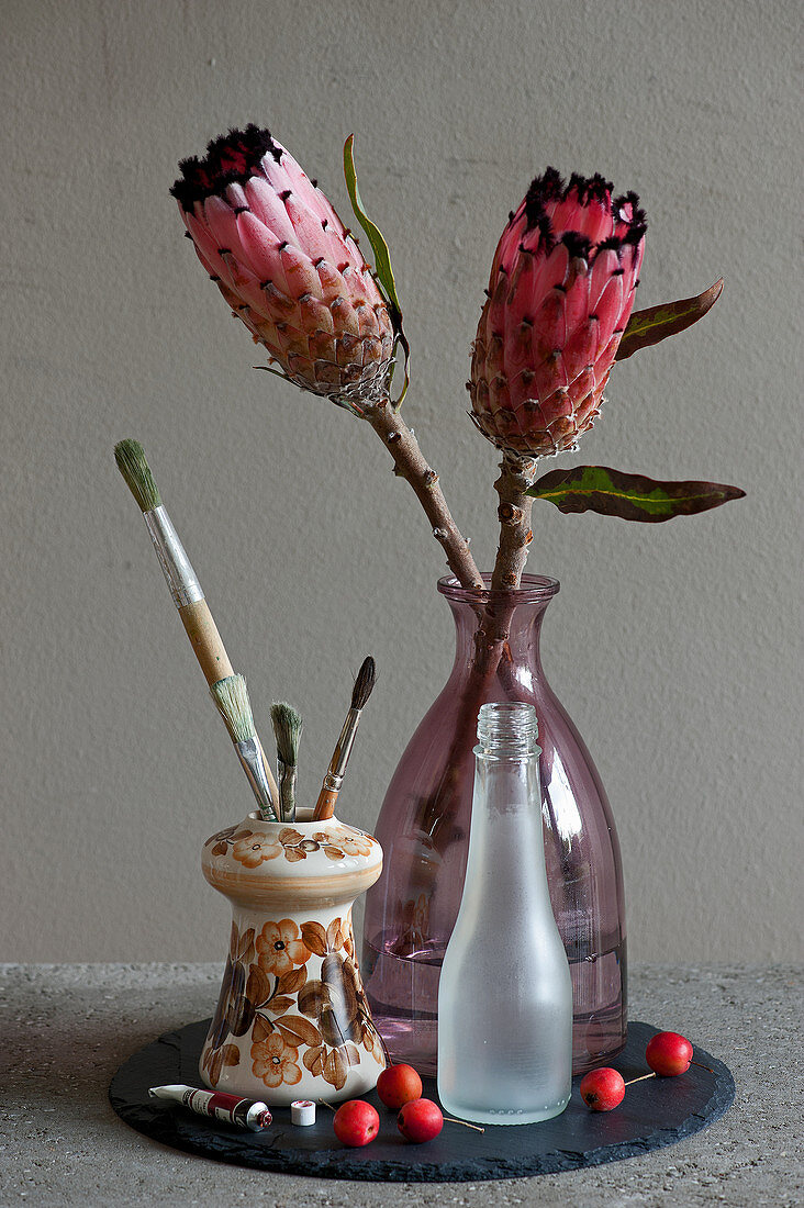 Protea-Blüten in Glasflasche